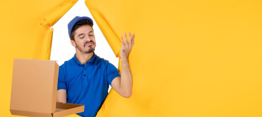 front-view-male-courier-holding-opened-pizza-box-yellow-space
